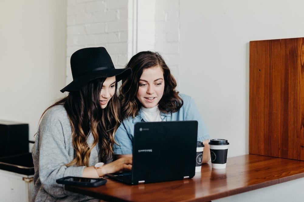 Two females looking at a computer together